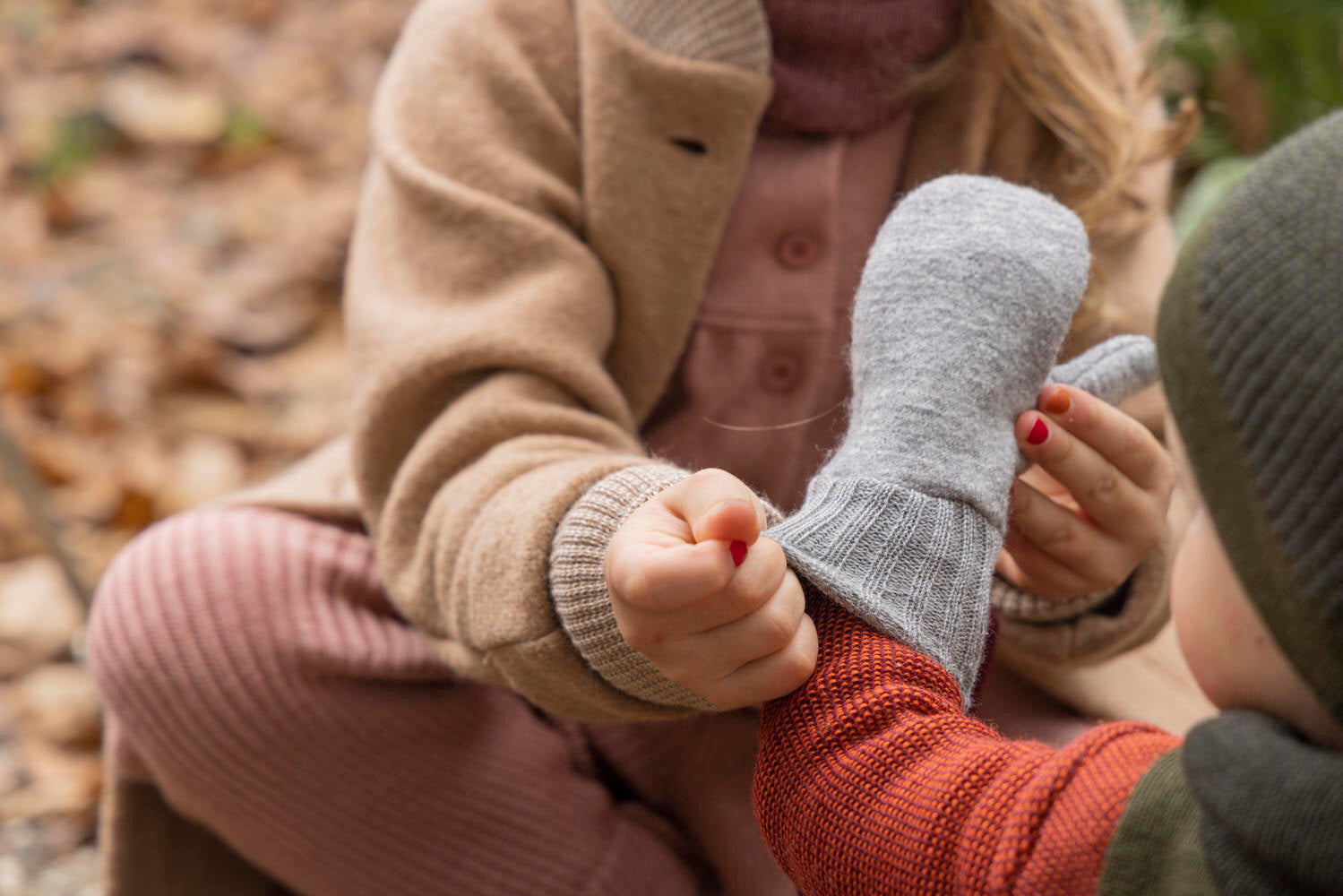 Lifestyle photo of the Disana boiled wool mittens in gray