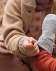Lifestyle photo of the Disana boiled wool mittens in gray