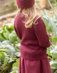 Lifestyle of child in Disana Aran wool sweater in cassis