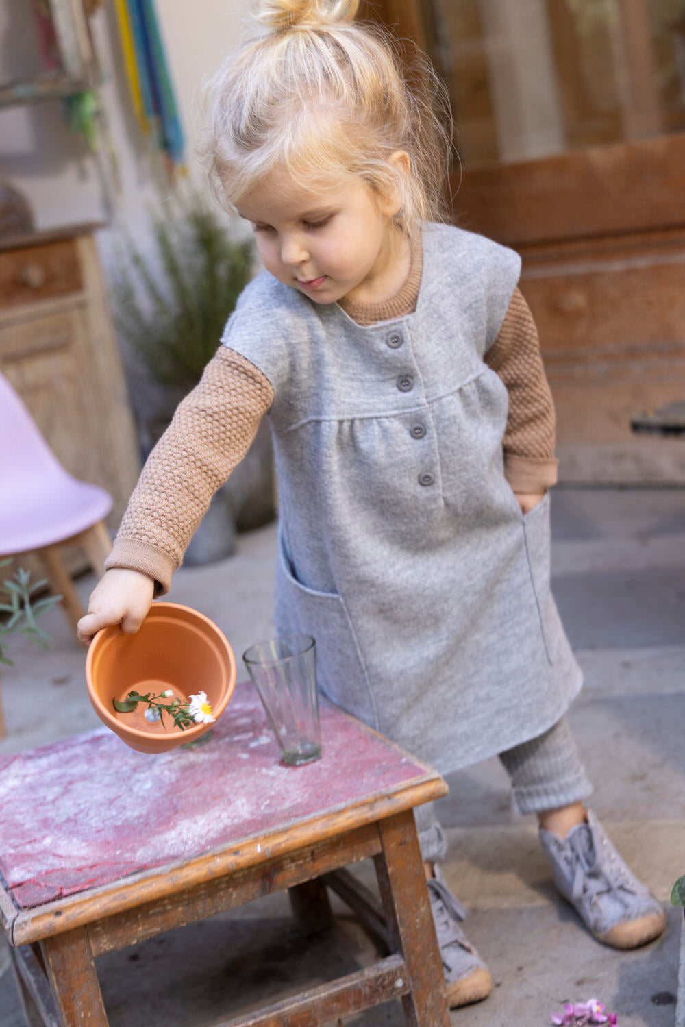 Lifestyle photo of the Disana children's boiled wool dress in gray.