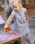 Lifestyle photo of the Disana children's boiled wool dress in gray.