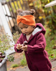 Lifestyle photo of toddler in orange wool Disana headband
