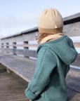 Lifestyle photo of child in Disana boiled wool overall in Eucalyptus