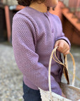 Lifestyle photo of the kids Disana honeycomb cardigan in lilac