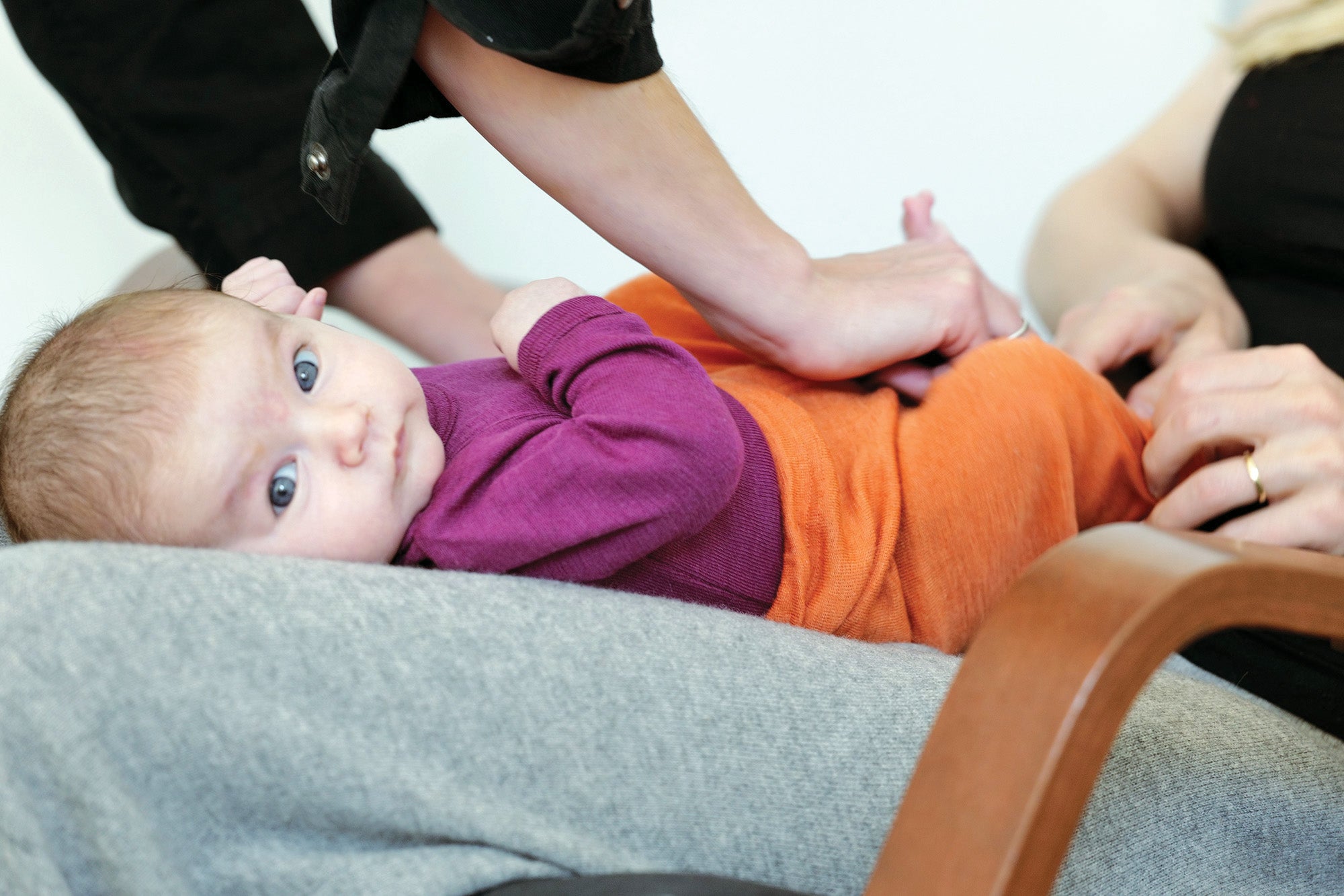lifestyle photo of baby in Engel long sleeve bodysuit and tangerine baby leggings by Engel