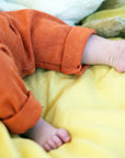 close up of Engel wool-silk baby leggings in tangerine