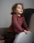 toddler in armchair wearing Disana melange sweater