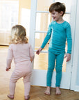 Two children wearing serendipity organics. Young girl in coral stripe bodysuit and leggings. Older boy in solid PJs not carried by Bigelow Lane.