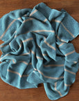 100% wool baby blanket in sky with a sand stripe. Made by Reiff