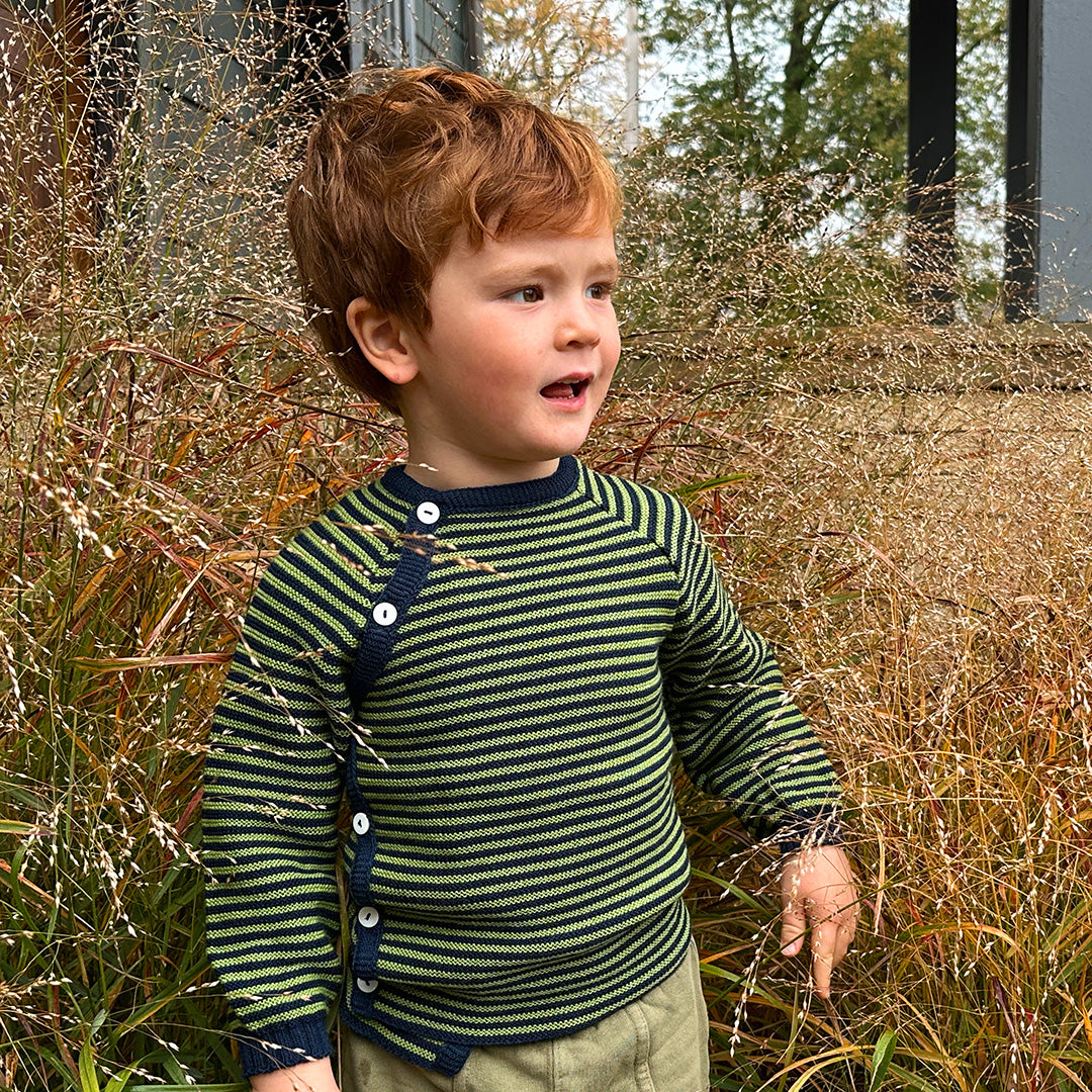 Toddler wearing a Reiff side button wool sweater in navy and apple stripe