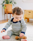 Lifestyle photo of engel striped bodysuit and leggings in navy-natural.