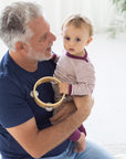 Father holding baby in Engel wool/silk thin stripe pajamas in orchid-natural