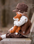 child sitting on a bench holding Senger Floppy small rust fox