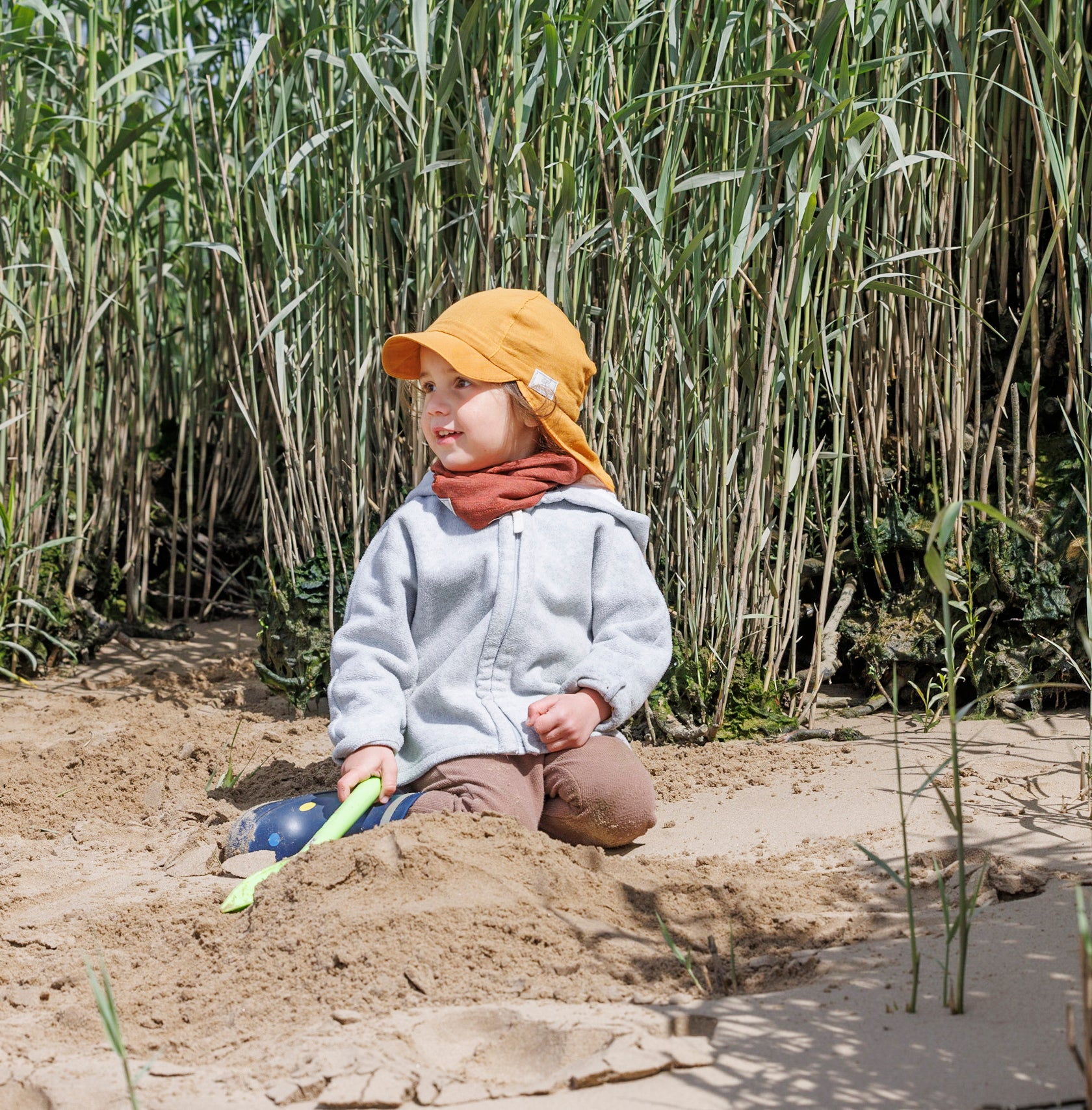 Child playing in Pickapooh Tony organic cotton sun hat in buttercup