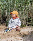 Child playing in Pickapooh Tony organic cotton sun hat in buttercup