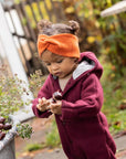 Lifestyle photo of toddler in orange wool Disana headband