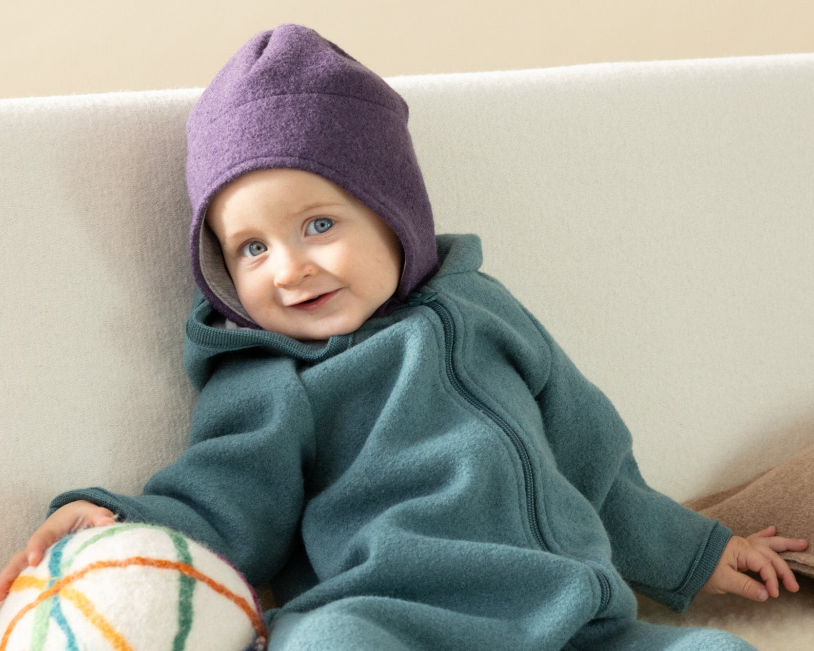 Baby in Disana boiled wool hat in aubergine