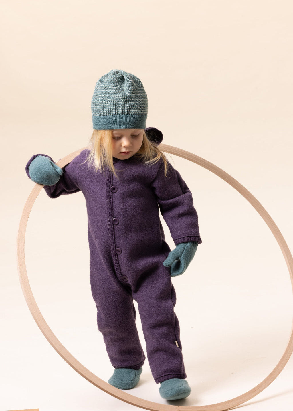 Lifestyle photo of girl in Disana boiled organic merino wool mittens in eucalytpus