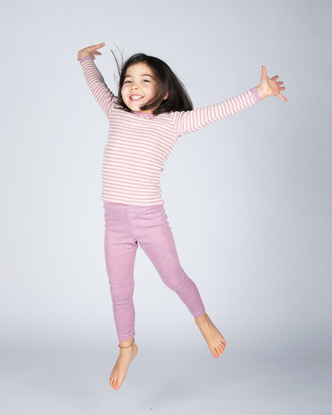 Girl in Engel children's 100% organic wool leggings in rose heather