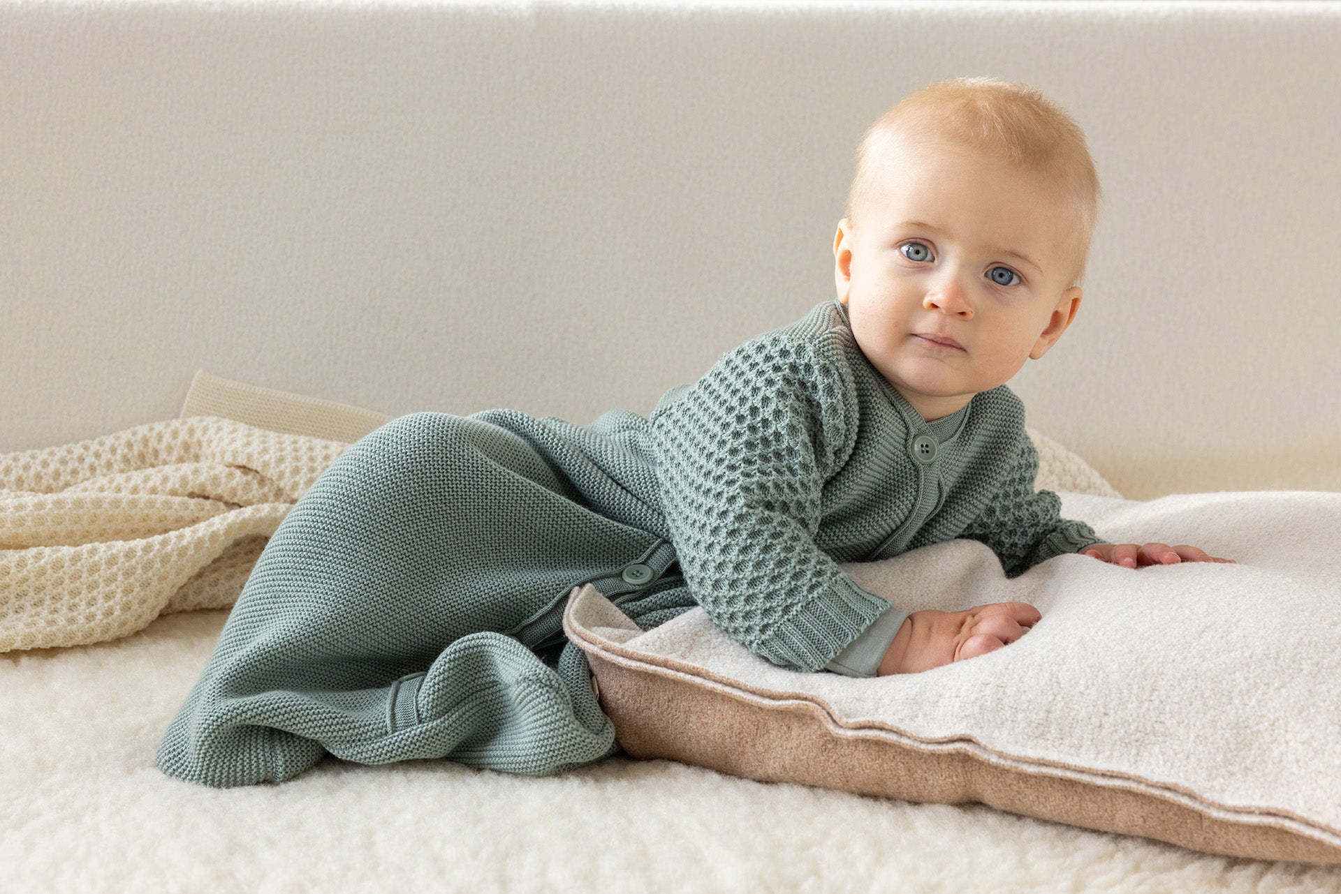 Baby in the Disana organic wool knit long sleeve sleep sack in jade