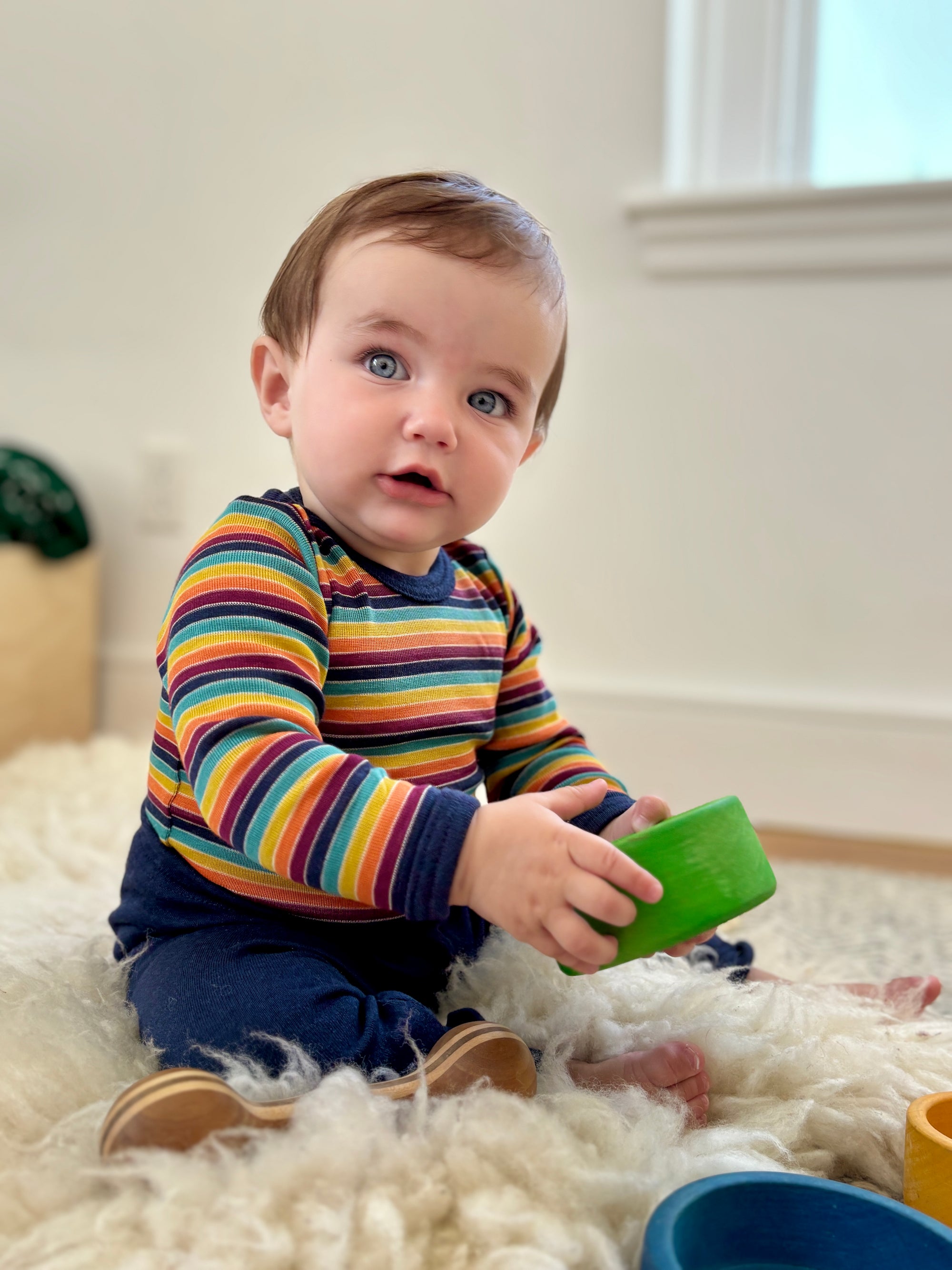 Baby wearing the Engel wool/silk bodysuit in retro stripe. 