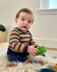 Baby wearing the Engel wool/silk bodysuit in retro stripe. 
