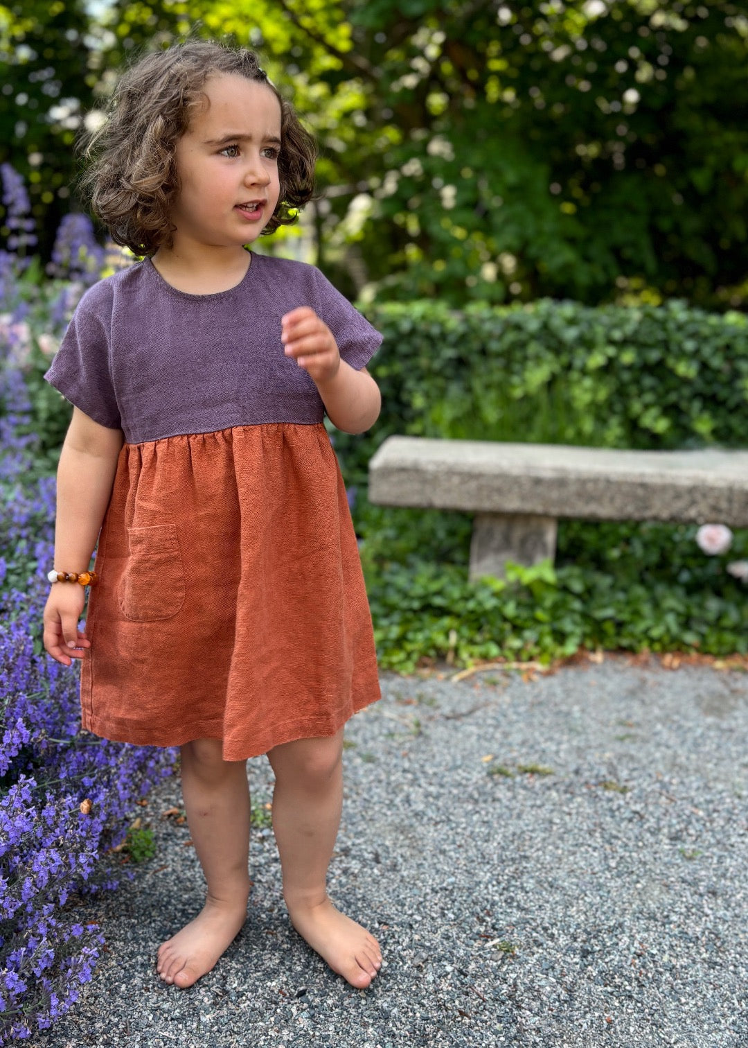 Girl in Bigelow Lane linen summer dress, in two-tone purple and clay