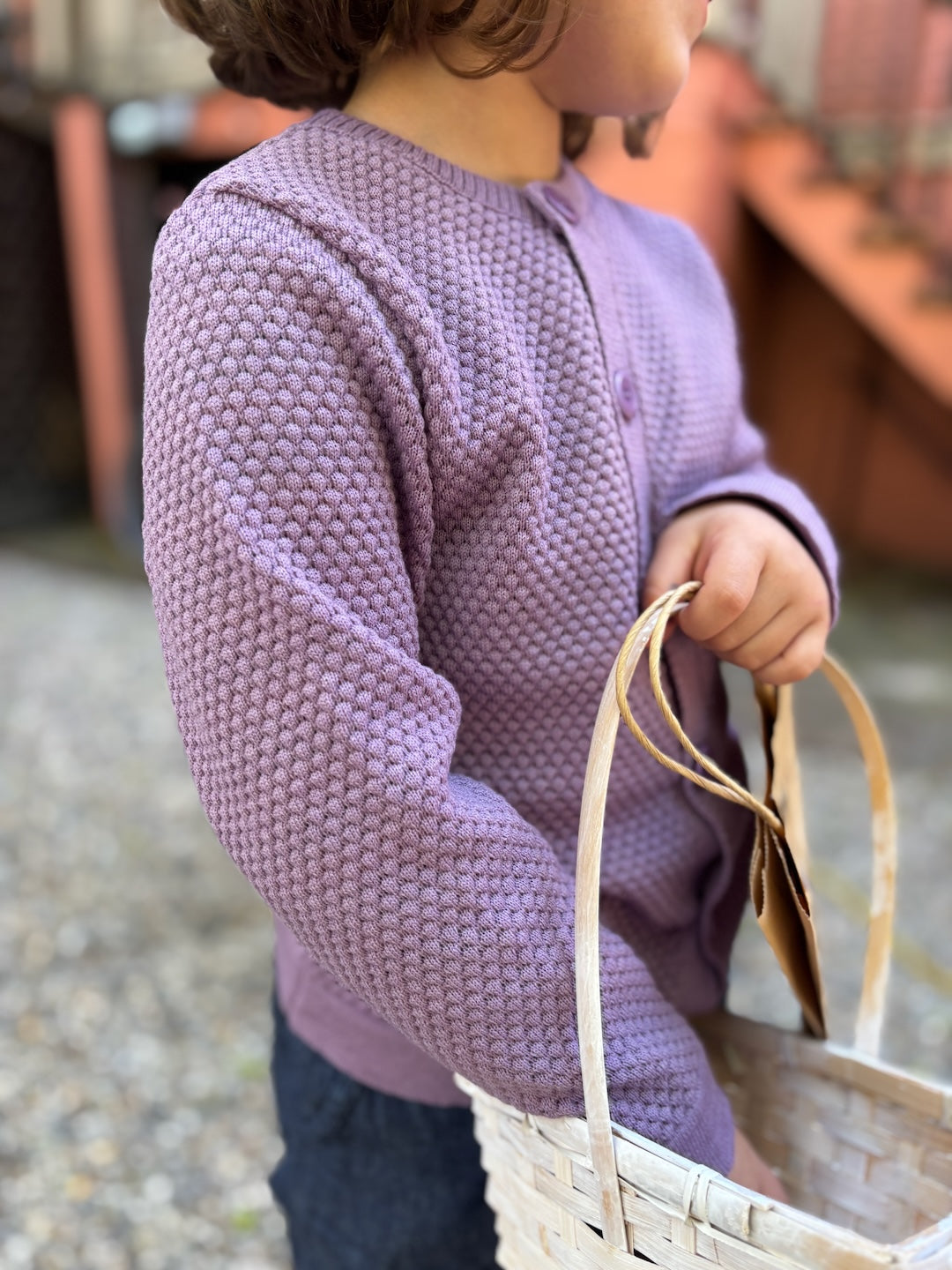Lifestyle photo of the kids Disana honeycomb cardigan in lilac