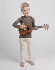 Boy playing ukulele in natural wool leggings