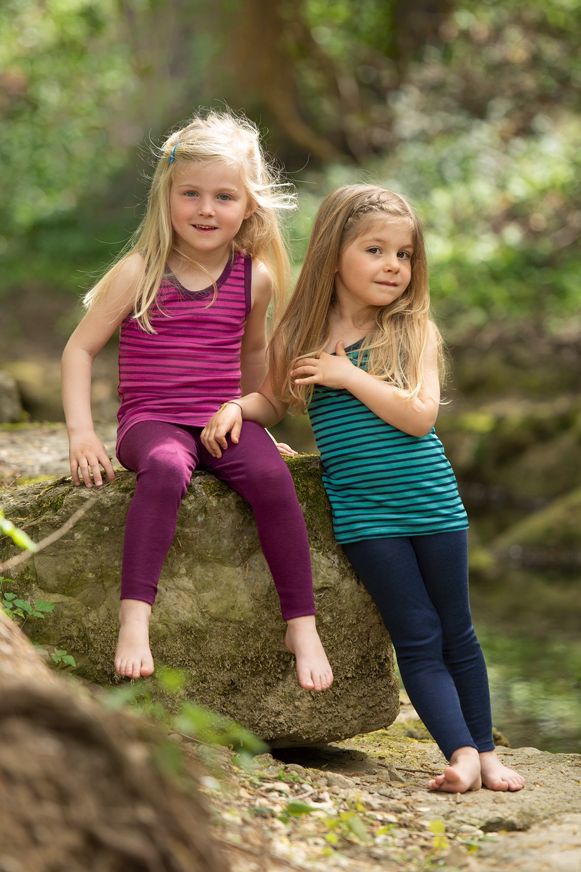 Two girls wearing Engel striped tanks in raspberry-orchid and navy-teal