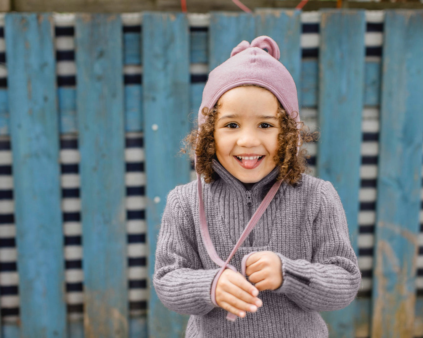 Girl wearing the Engel wool fleece hat with tassel in rose melange