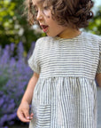 Girl in thin stripe linen summer dress by Bigelow Lane