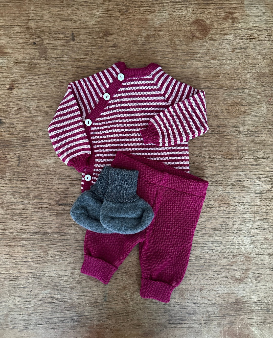 Striped wool cardigan in berry and pink. Berry wool knit pants and charcoal wool fleece booties. All made by Reiff