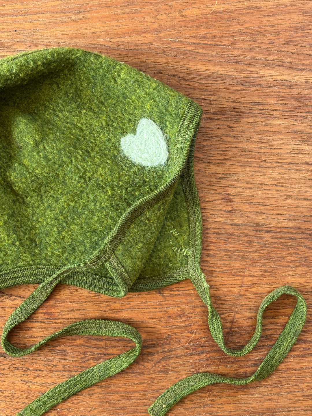 Preloved Siskin (Engel) wool fleece bonnet in green. Zoom in on mending