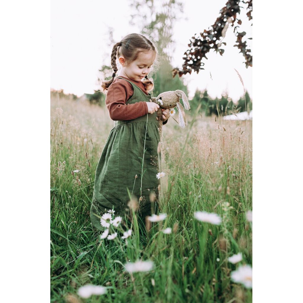 Young girl in a field playing with the Large Senger organic cotton non-toxic floppy beige rabbit