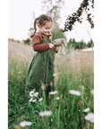 Young girl in a field playing with the Large Senger organic cotton non-toxic floppy beige rabbit