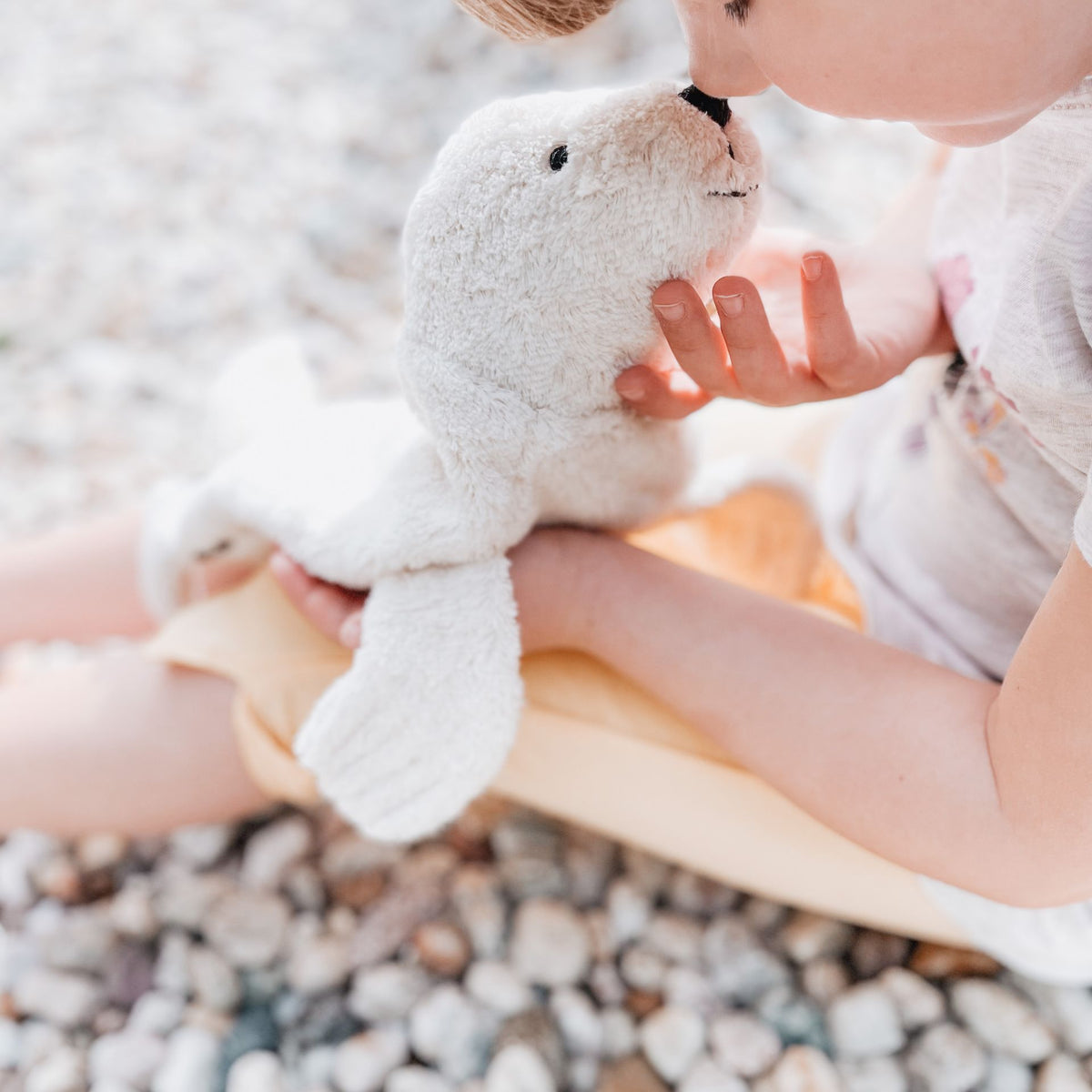 Small boy playing with the Senger Cuddly organic cotton non-toxic small white seal 
