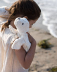 Young girl holding a Senger organic cotton non-toxic Cuddly small white seal on each shoulder