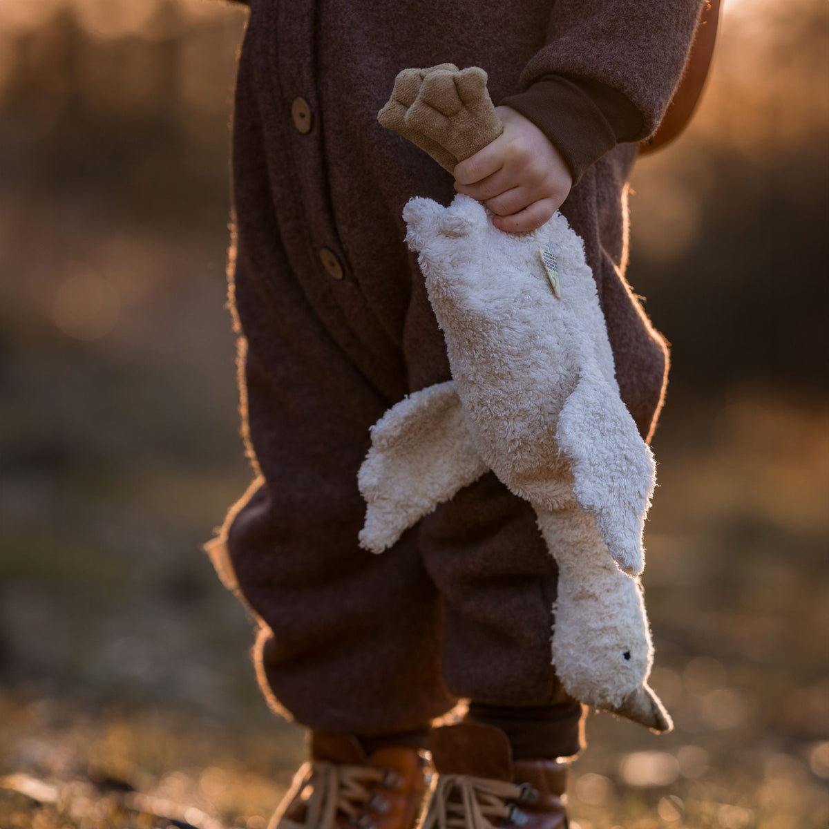 Young child holding the small cuddly Senger organic cotton non-toxic goose