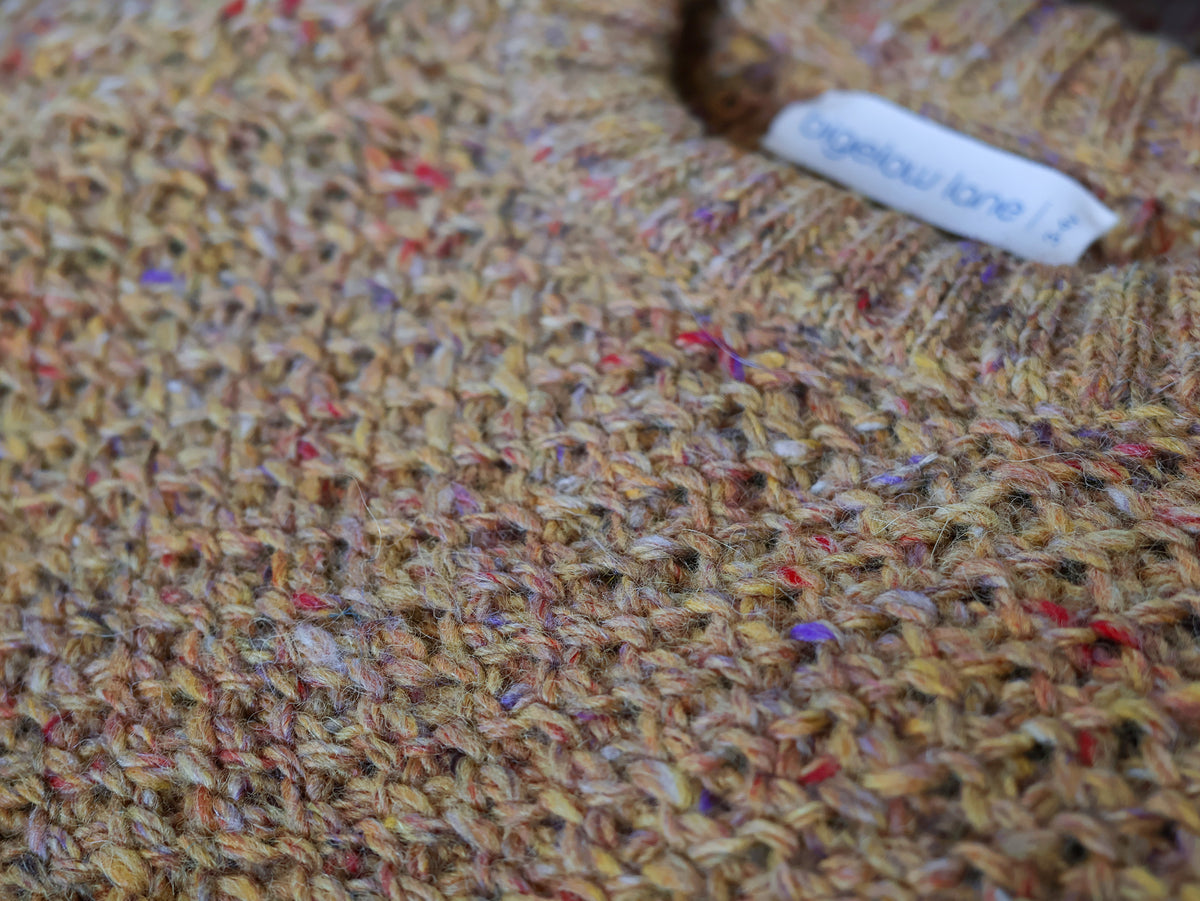 Close up of the tuck sweater in wheat