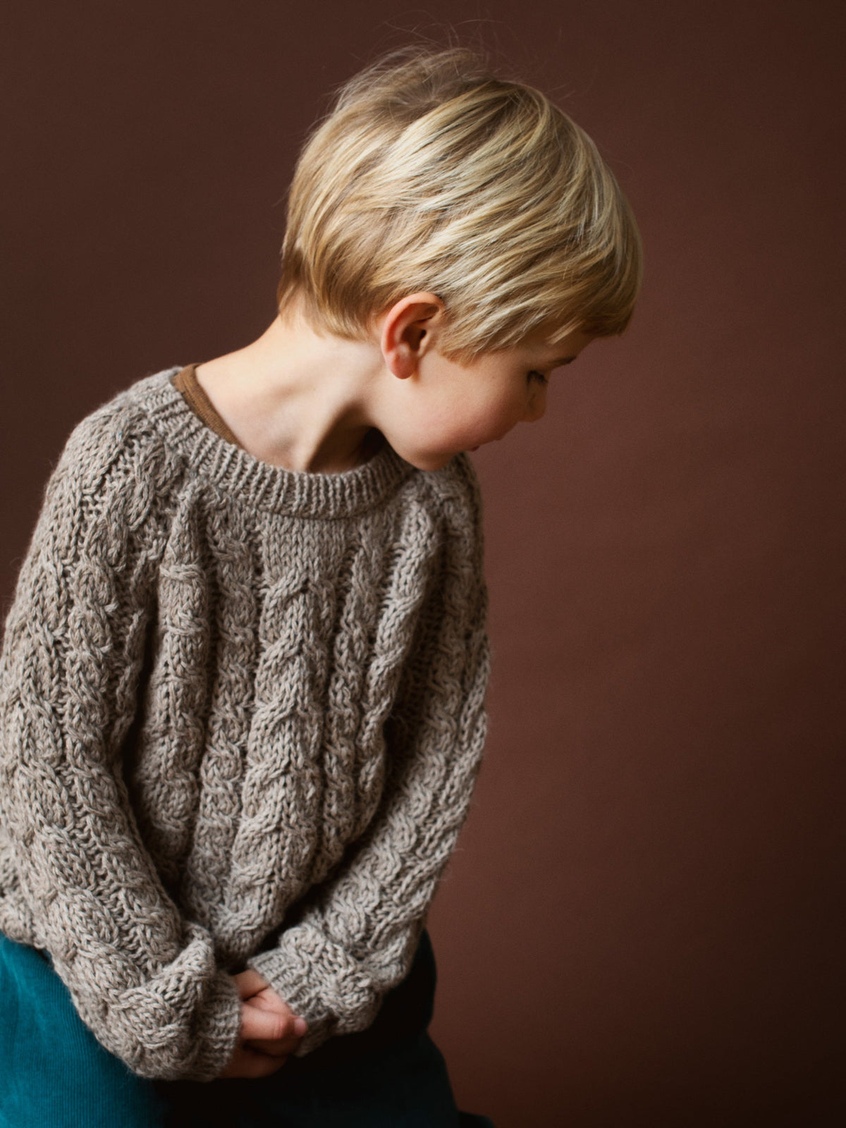 Boy wearing Serendipity Organics alpaca cable sweater in sand
