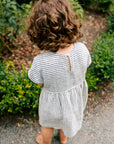 Girl in thin stripe linen summer dress by Bigelow Lane