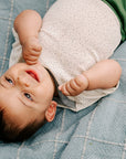 baby in Engel wool/silk short sleeve bodysuit in natural/dots