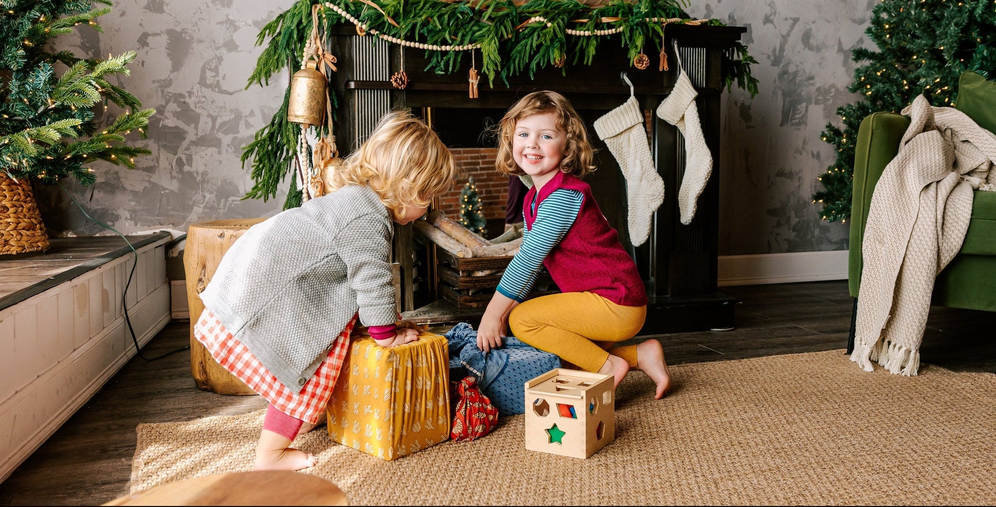 Two girls dressed in Bigelow Lane clothes, readying to open presents