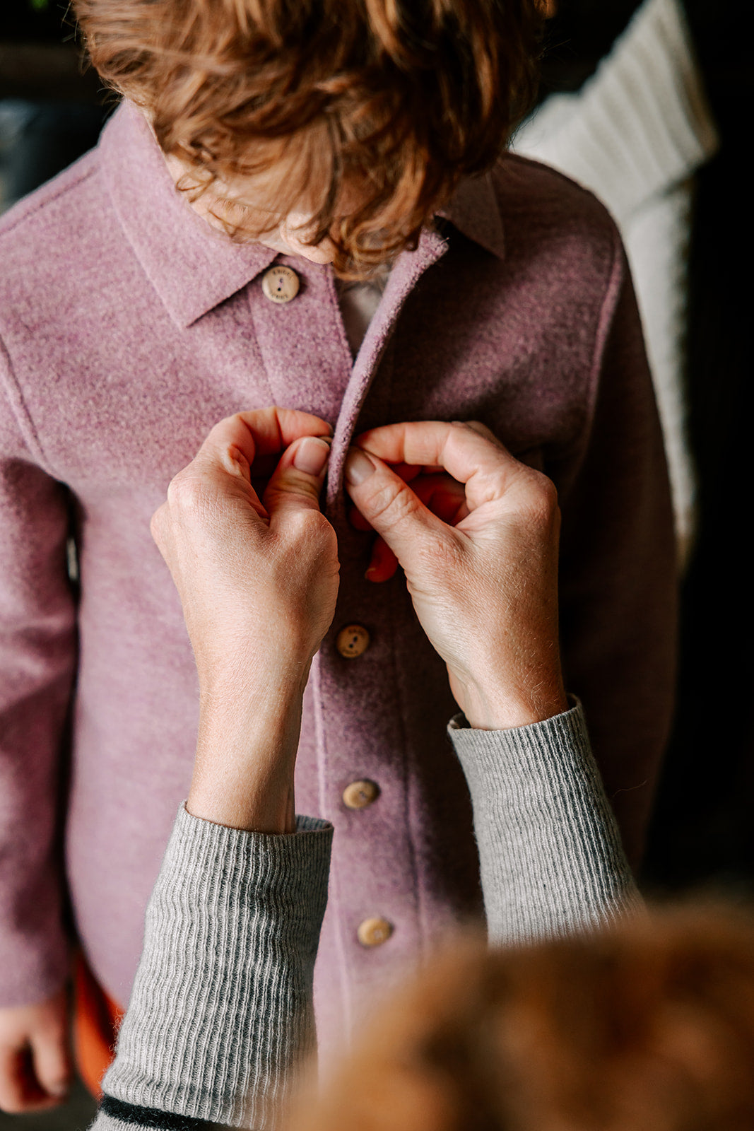 Mother dressing child in Engel boiled wool shacket in rose melange 