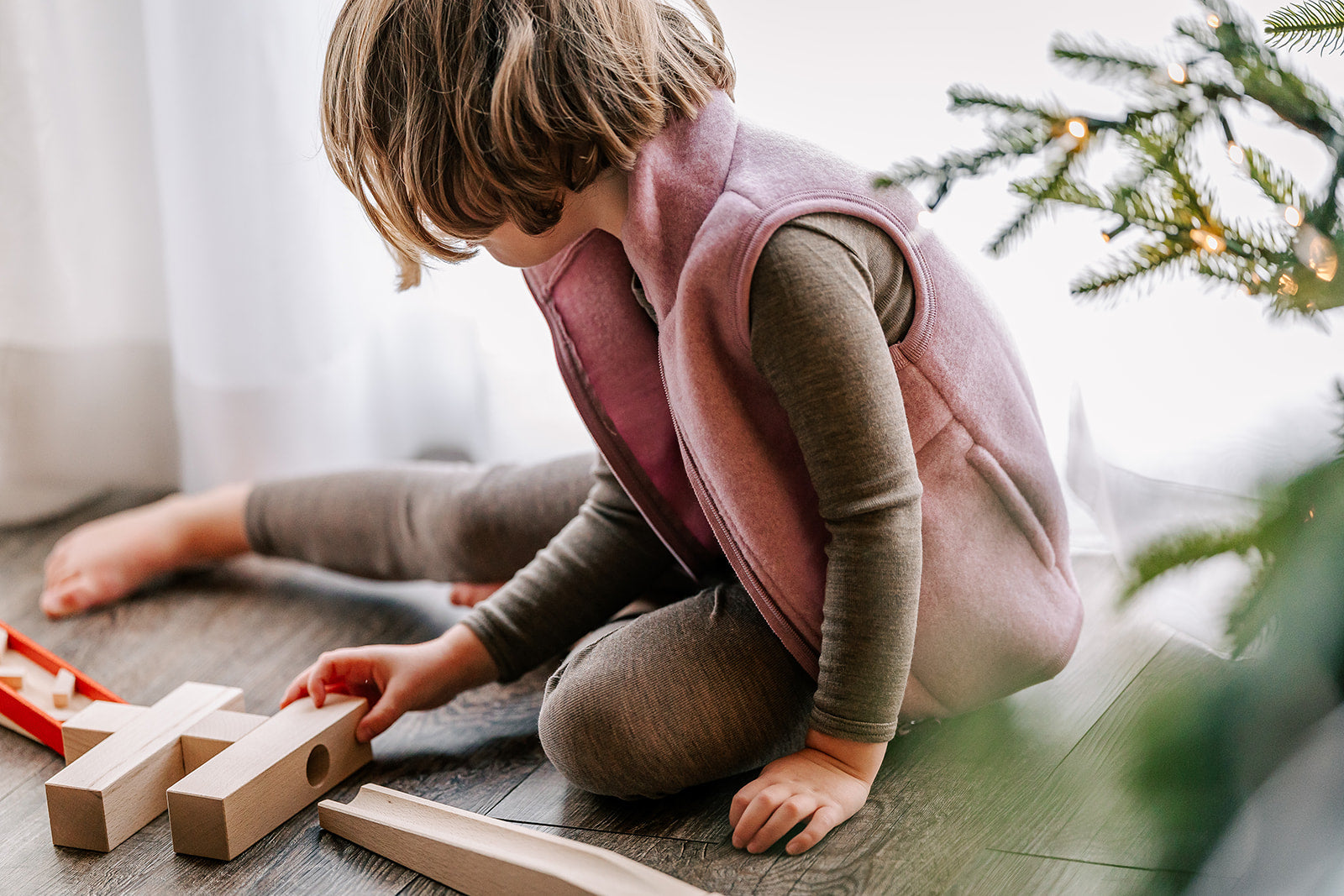 Girl playing in Engel fleece vest in rose melange