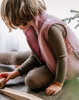 Girl playing in Engel fleece vest in rose melange