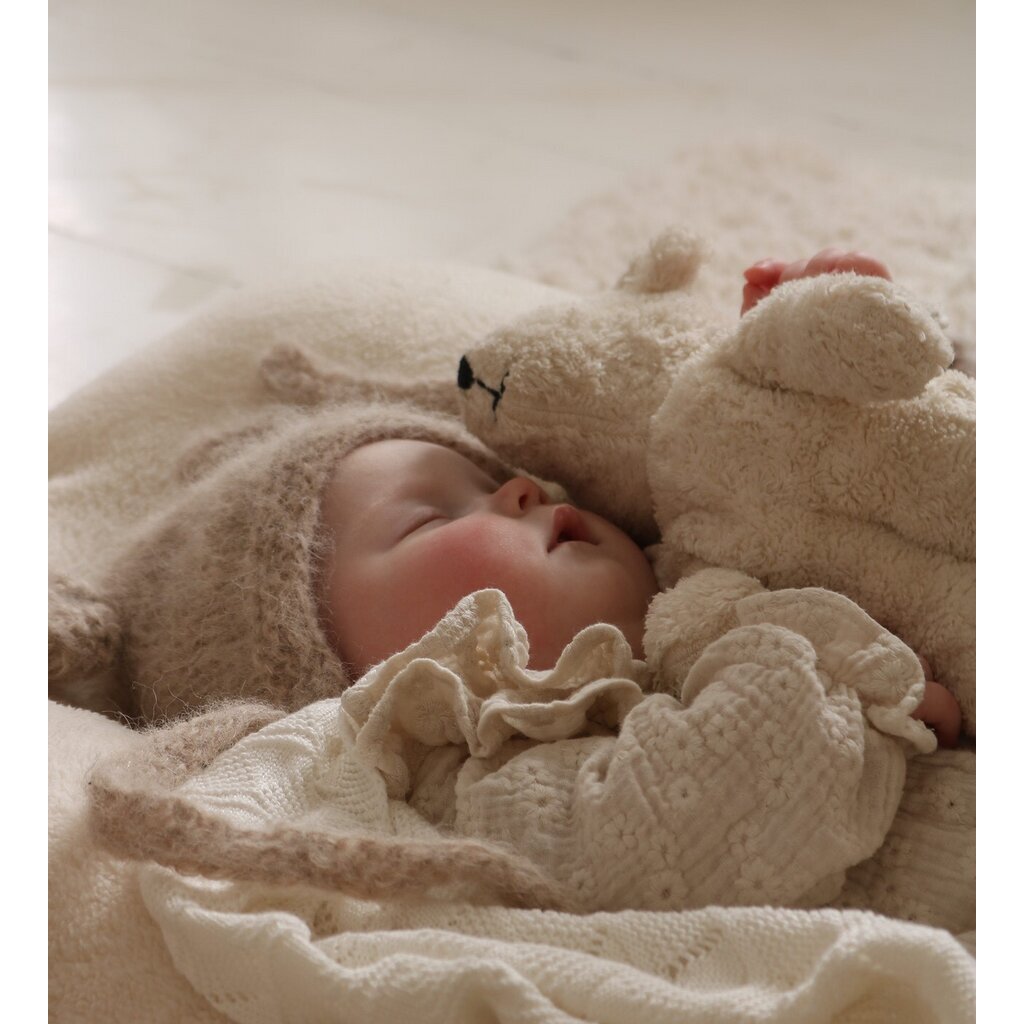 Baby asleep next to Senger non-organic Floppy small white bear