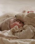 Baby asleep next to Senger non-organic Floppy small white bear