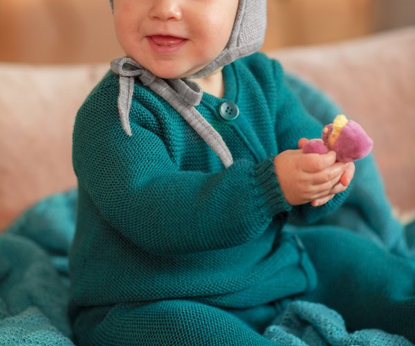 Baby in disana knitted overall in pacific color